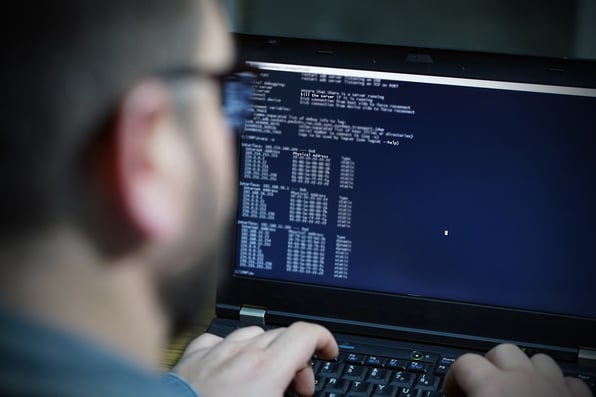 Man sitting at computer writing code